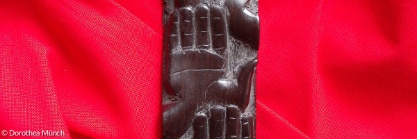 ein geschnitztes Kreuz auf rotem Hintergrund