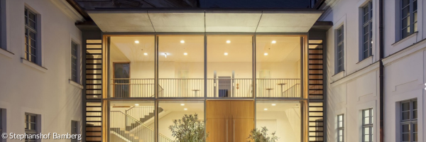 ein hell erleuchtetes Gebäude mit großer Glasfront