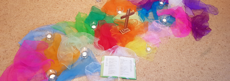 bunte Tücher auf dem Boden, ein Kreuz