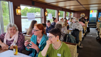 vielen Menschen sitzen an Tischen in einem Boot