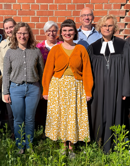 fünf Frauen und ein Mann stehen als Gruppenfoto vor einer Ziegelwand