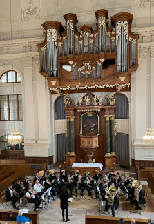 Vor einem Altar spielt ein Bläserensemble