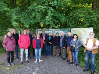 mehrere Menschen im Gruppenfoto vor grünen Bäumen