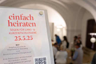 Ein Plakat von einfach heiraten, im Hintergrund viele Menschen