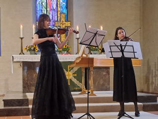 zwei Violinistinnen spielen in einem Altarraum