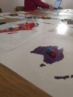 Landkarten auf denen Gummibärchen liegen