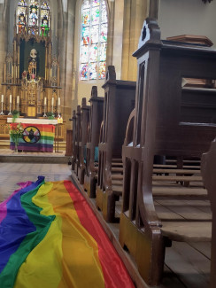 ein Altarraum mit einer Regenbogenfahne