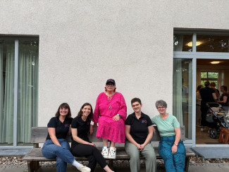 fünf Frauen sitzen auf einer Bank
