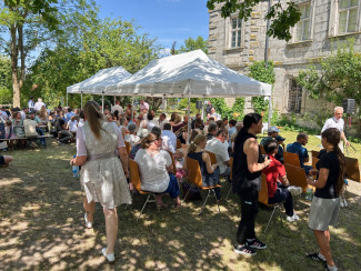 Viele Menschen unter Sonnenschirmen und an Bierbänken sitzend im Schlosshof Weingartsgreuth