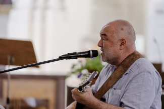 Wolfgang Buck mit Gitarre und Mikrofon in der Stephanskirche