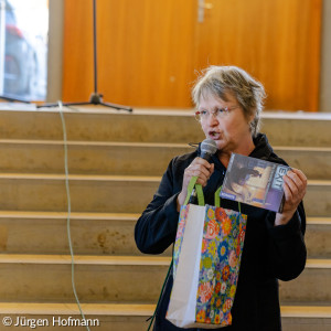 Diakonin Hofmann hält ein Geschenk für Anne Buckel in der Hand